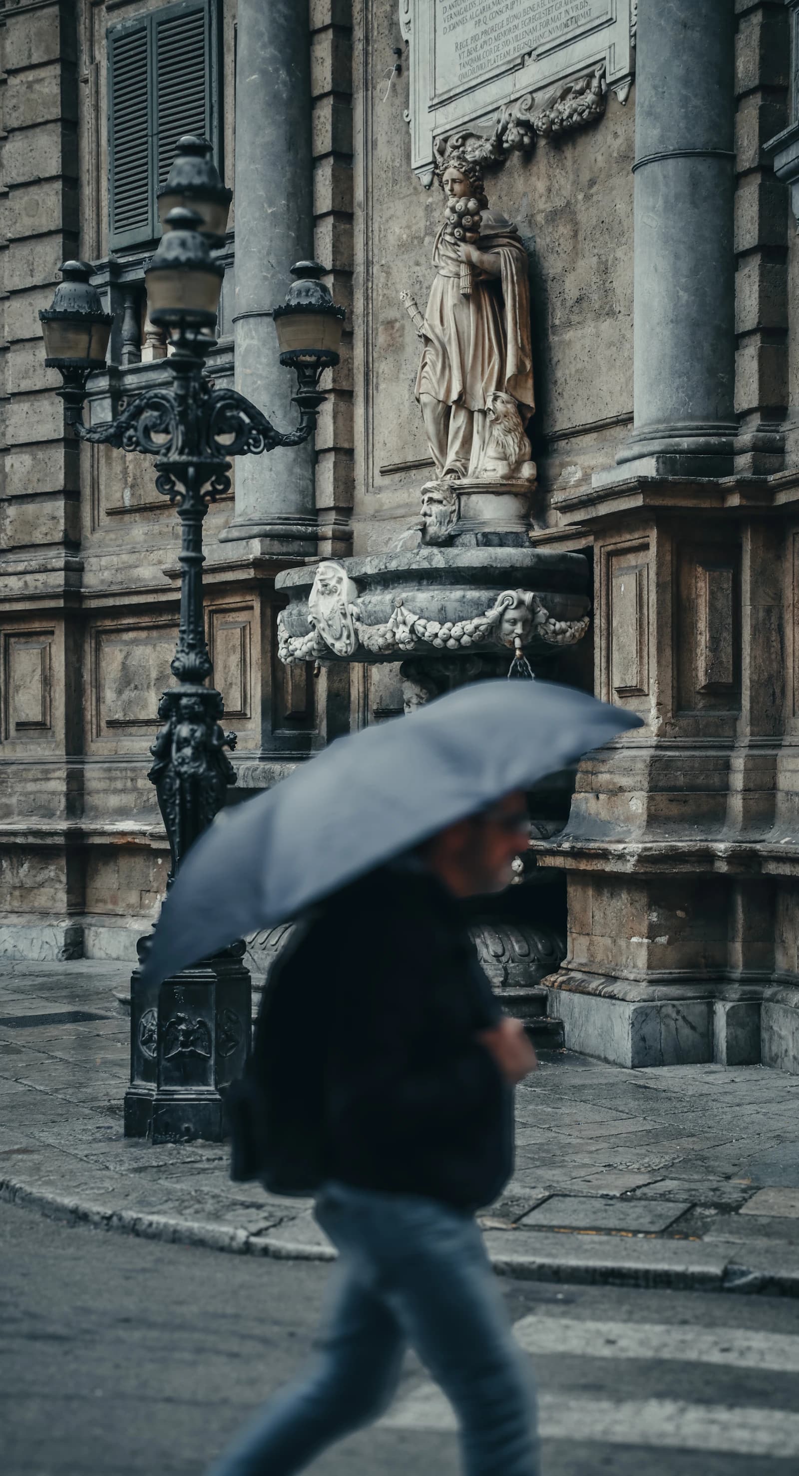 Sculpted Baroque façade at Quattro Canti on a rainy Palermo street