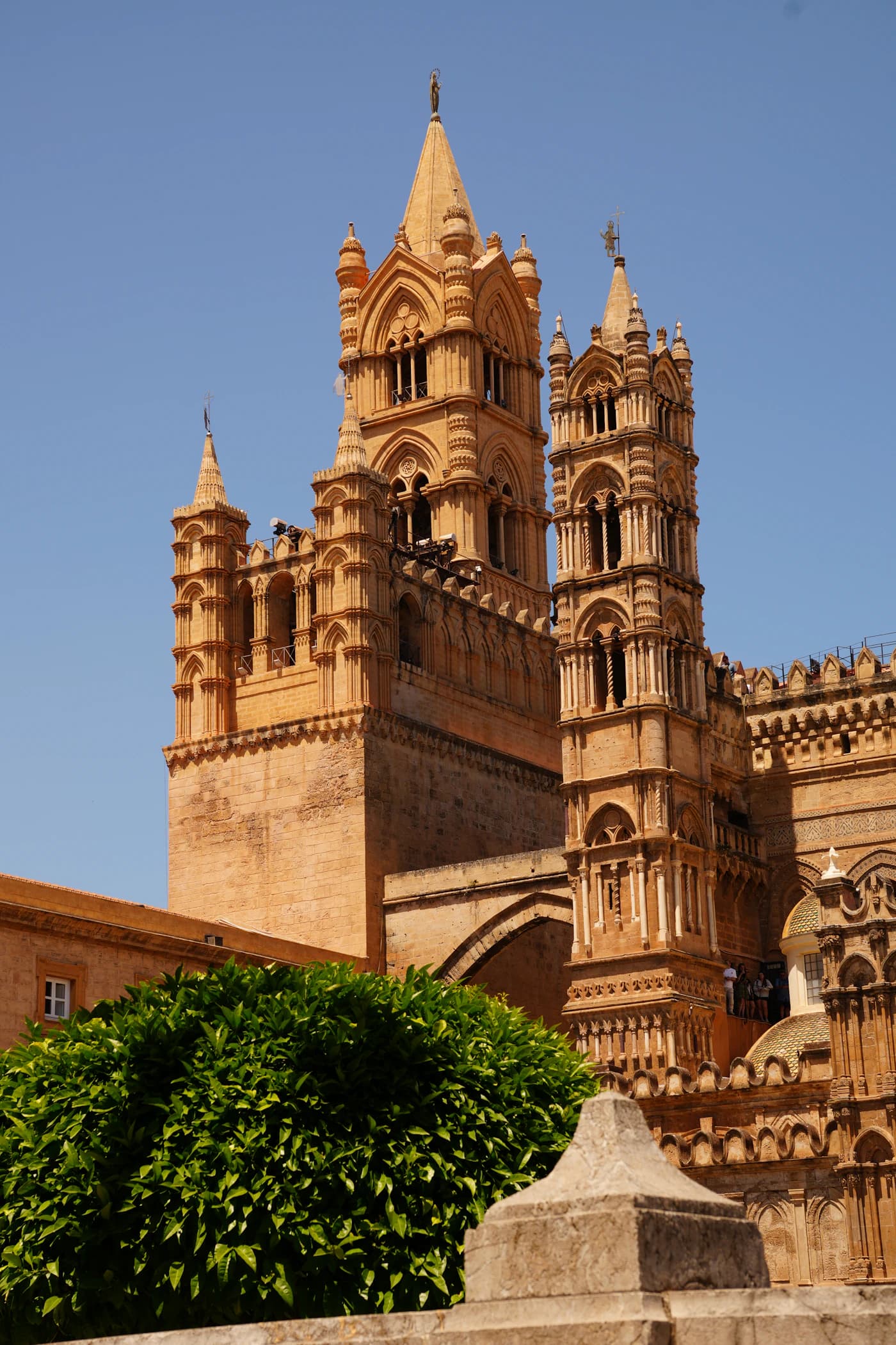 Warm stone towers of Palermo Cathedral against a clear blue sky
